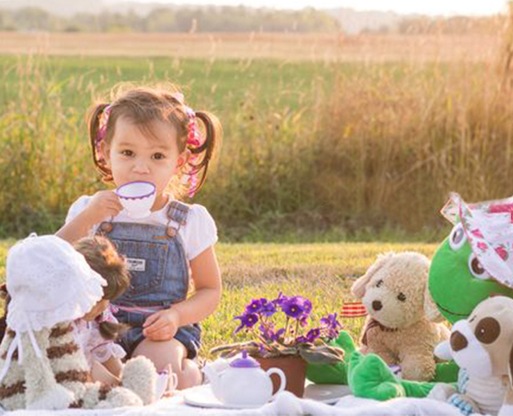 baby sitting in park with toys