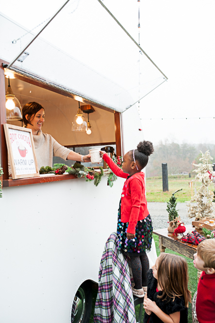little girl at christmas hot cocoa stand