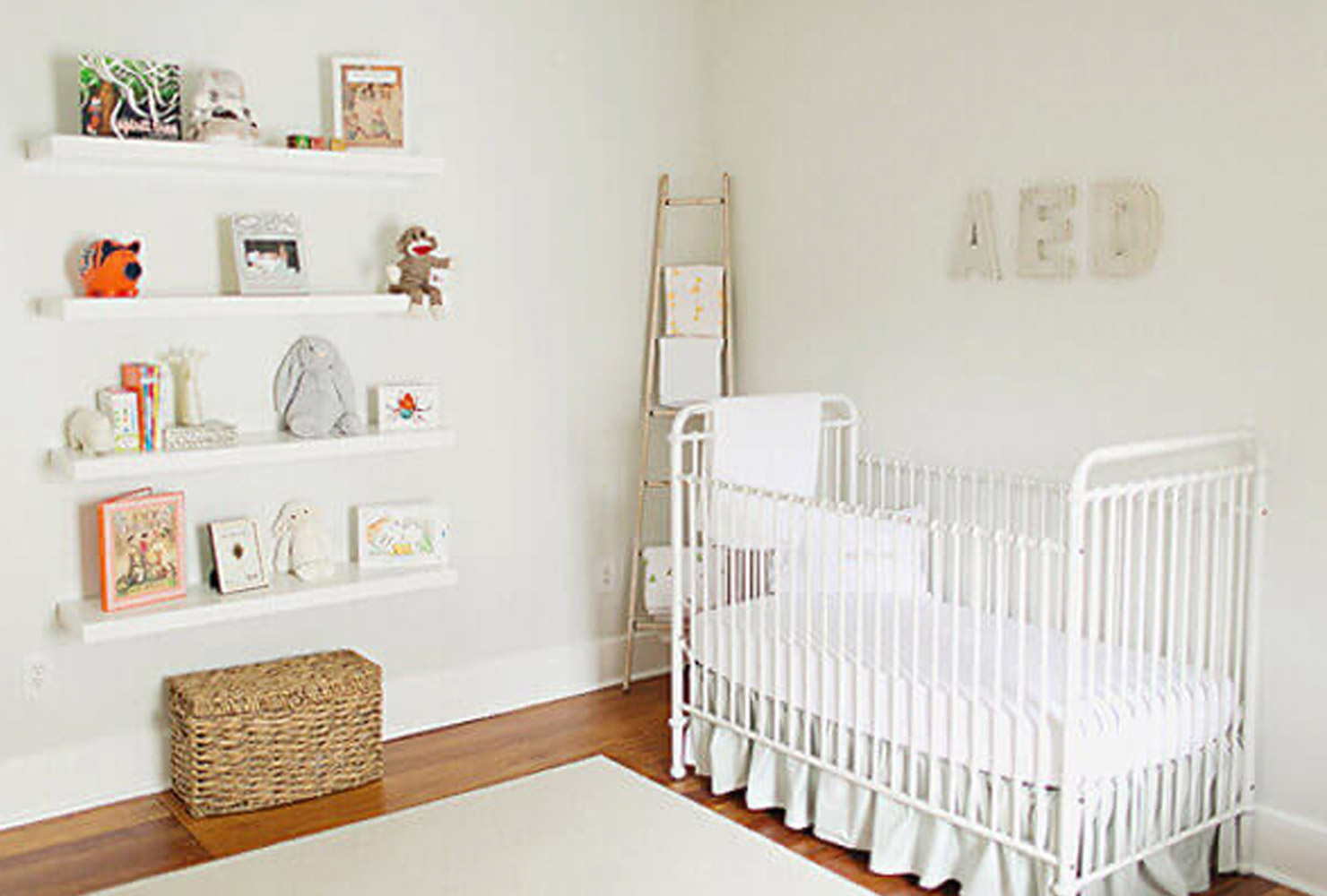 White nursery decor with crib and bookshelf.