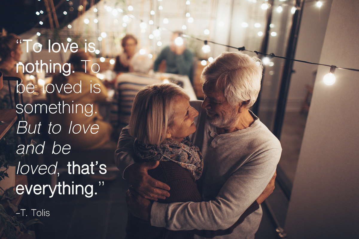 Portrait of a senior couple who celebrates their anniversary at a family dinner, together with their children, grandchildren and friends with a happy 50th anniversary quotes overlay