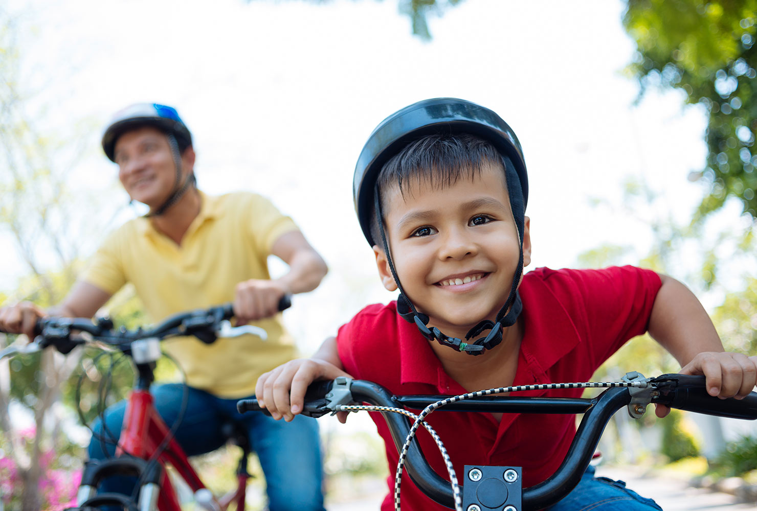 kid riding a bike with his dad