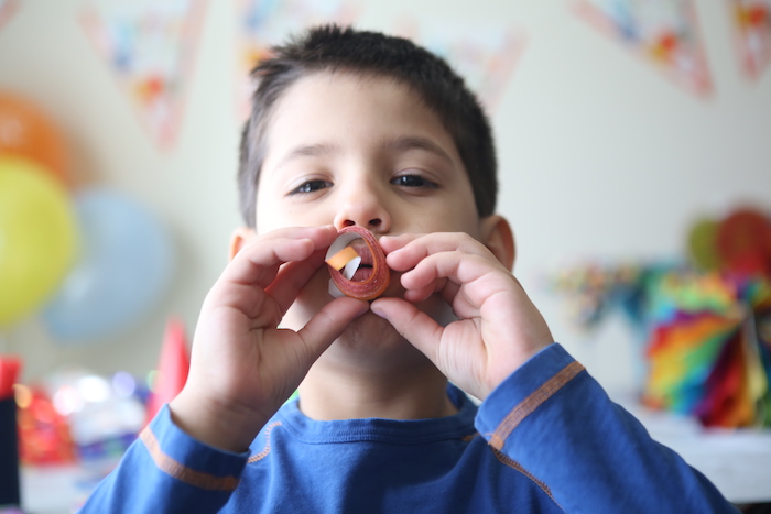 birthday boy blowing whistle