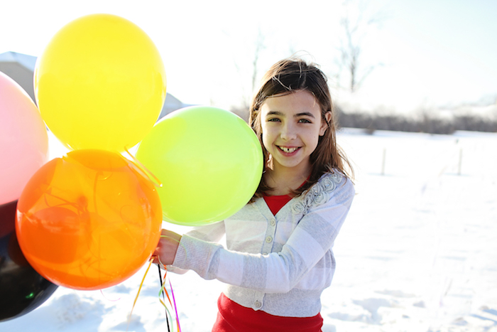 girl holding balloons
