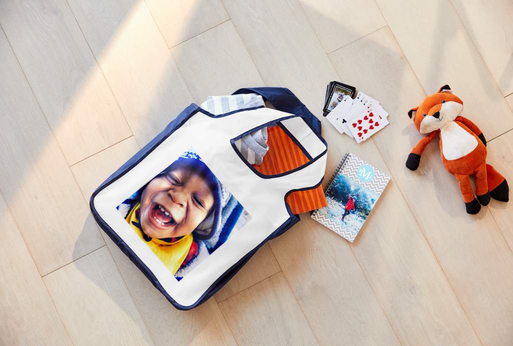 A reusable gift bag full of fun party favors spilling out.