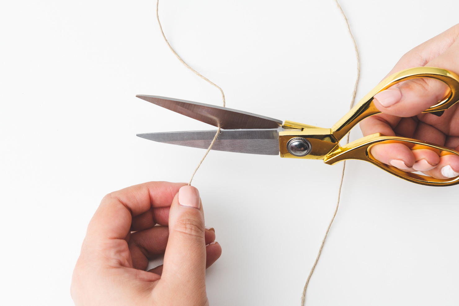 gold scissors cutting twine