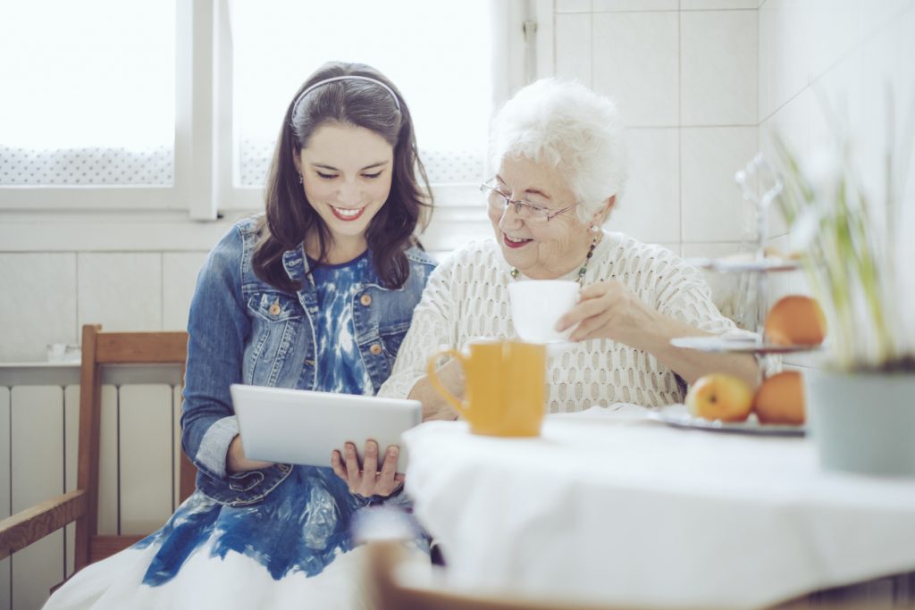 Granddaughter helps Grandma video call family. 