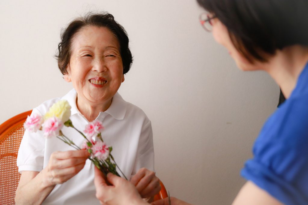 Daughter is giving flower to her mother for her birthday.