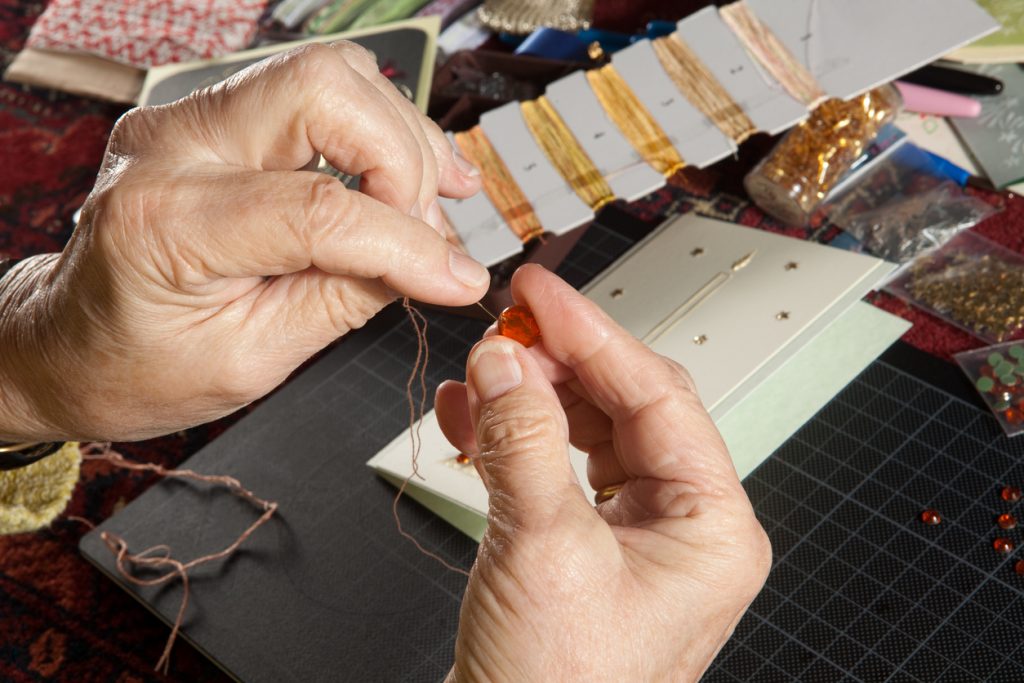 Hands of a woman crafting and scrap-booking homemade cards.