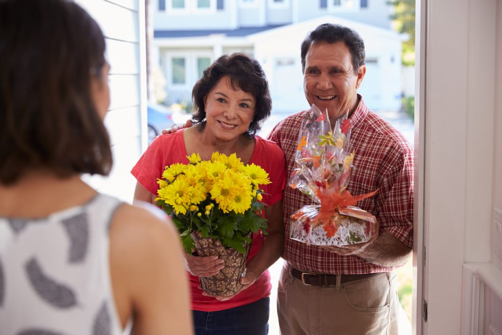Parents Visiting Daughter In New Home and gifting flowers.