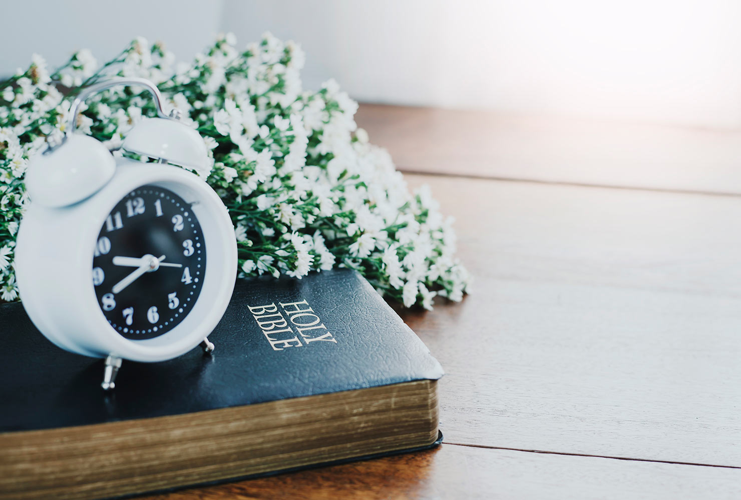 Bouquet of flowers next to Bible.