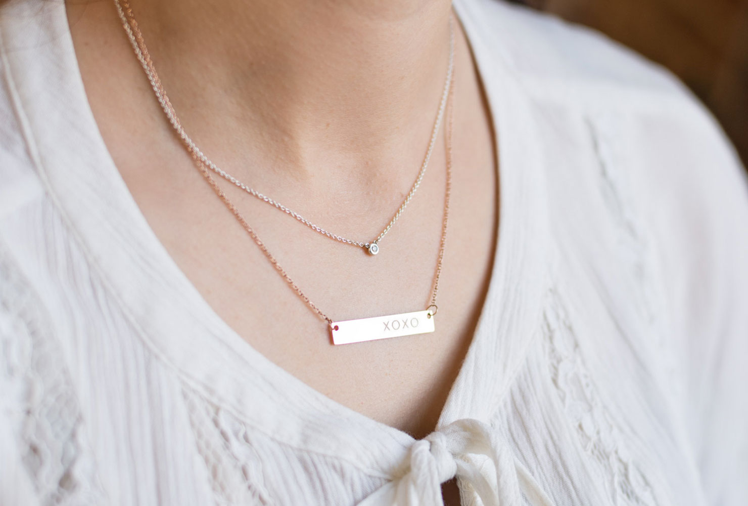 Woman wearing layered necklaces.