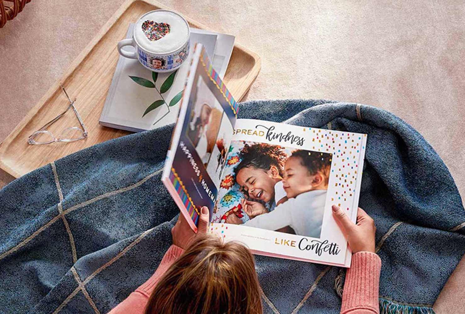 Girl reading photo book with blanket.