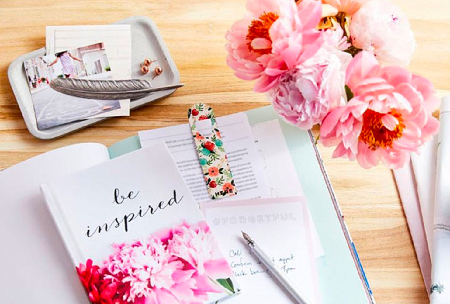 Floral patterned journal next to vase of flowers.