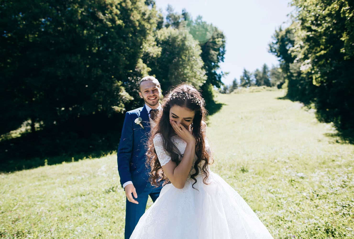Married couple smiling in field.