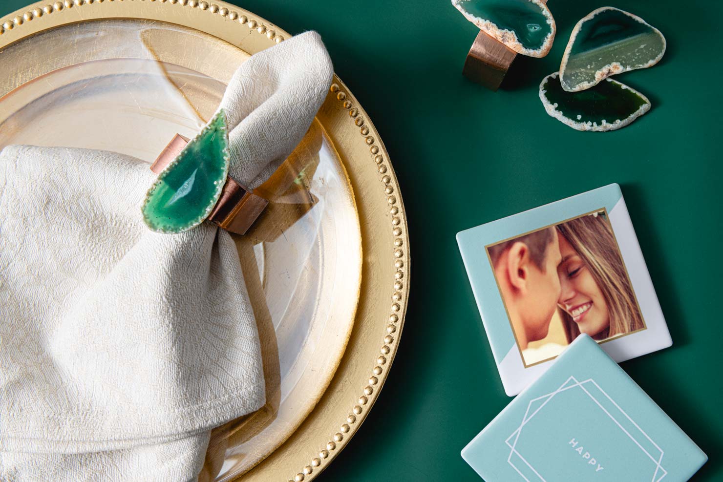 A geode napkin ring next to photo coasters.