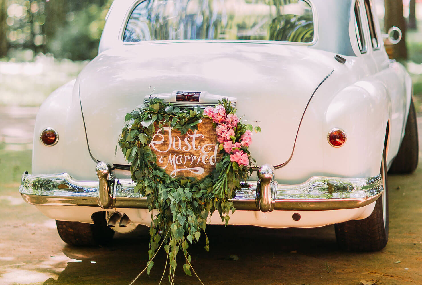 Vintage getaway car with a just married sign on the back.