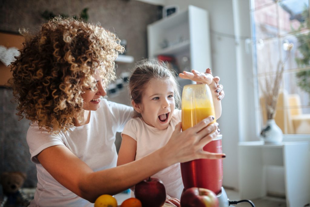 Mother and daughter making smoothie