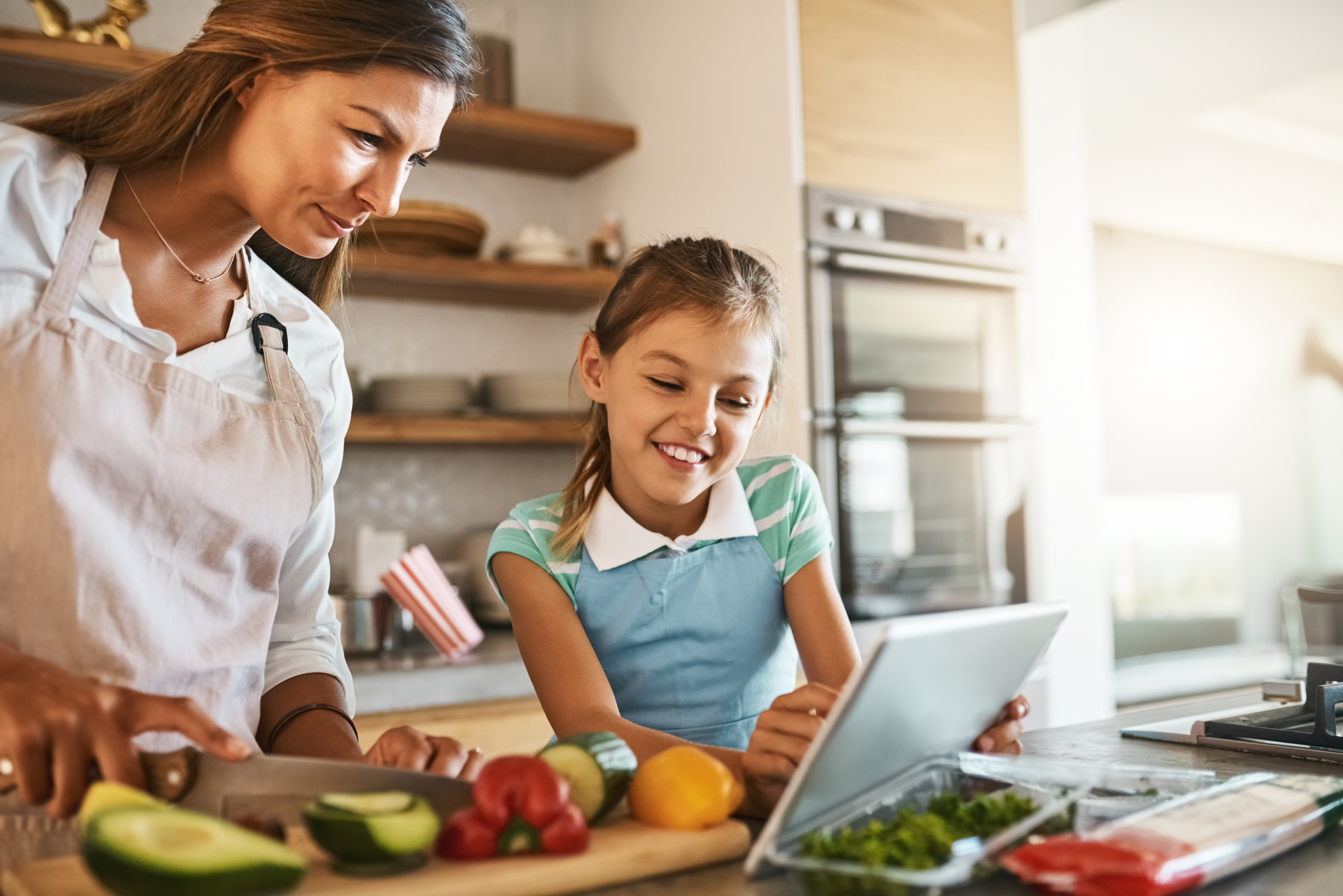 Shot of a mother and her young daughter trying out a new recipe in the kitchen together